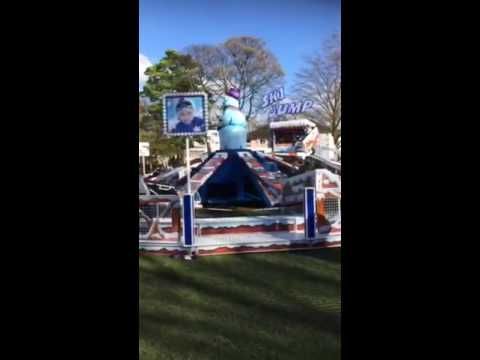 Giant Ski Jump flying coaster in operation with riders in the sleigh-style cars