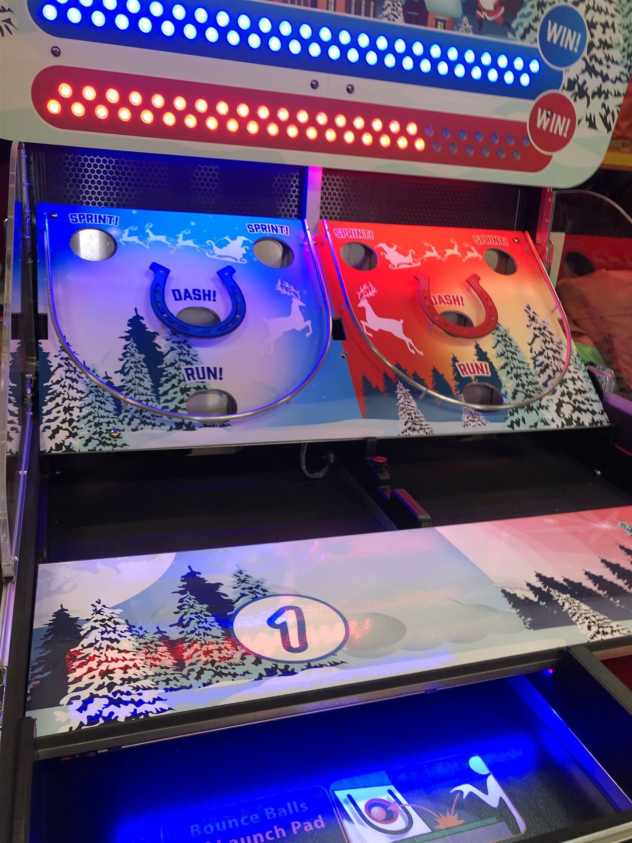 Close-up of the blue launch pad and lane one on the Bounce A Ball Reindeer Racing cabinet