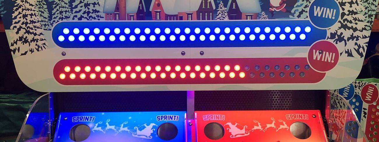 Front view of the Bounce A Ball Reindeer Racing cabinet with blue and red illuminated scoring tracks