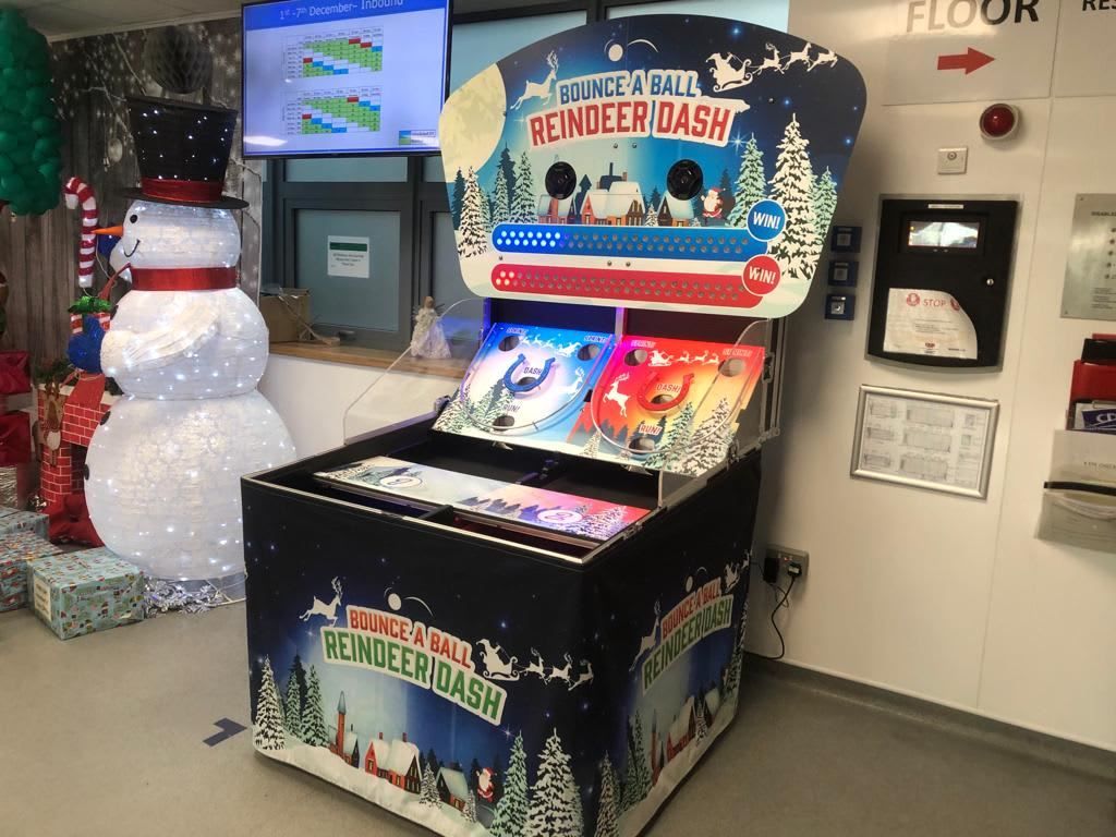 The Bounce A Ball Reindeer Racing cabinet installed in an office reception beside a snowman decoration