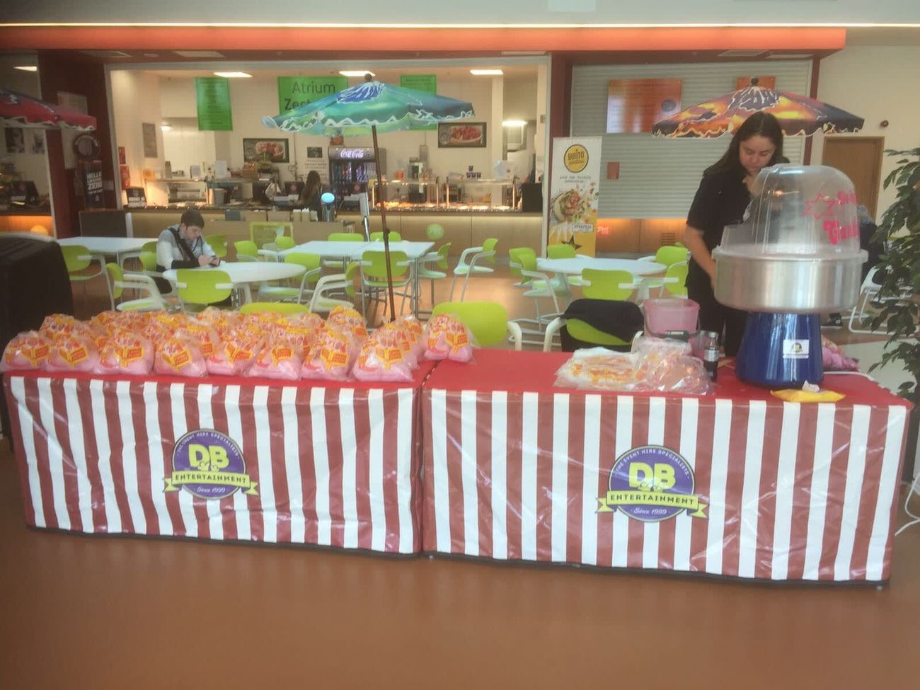 The candy floss stall set up at an outdoor event with branded barriers