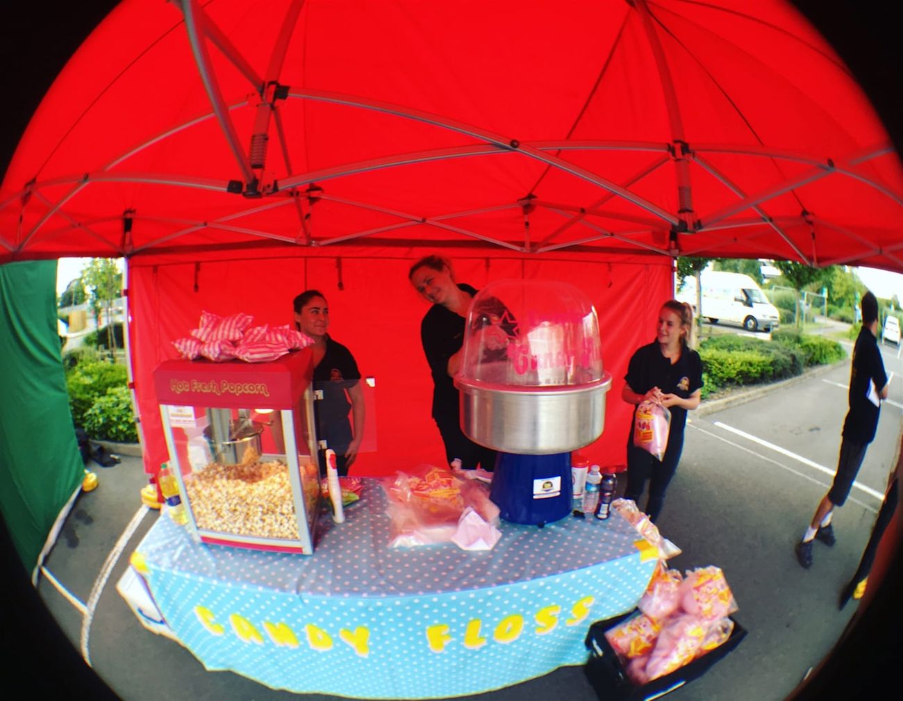 Candy floss stall under its red gazebo, with CANDY FLOSS lettering on the table front and portions ready to serve