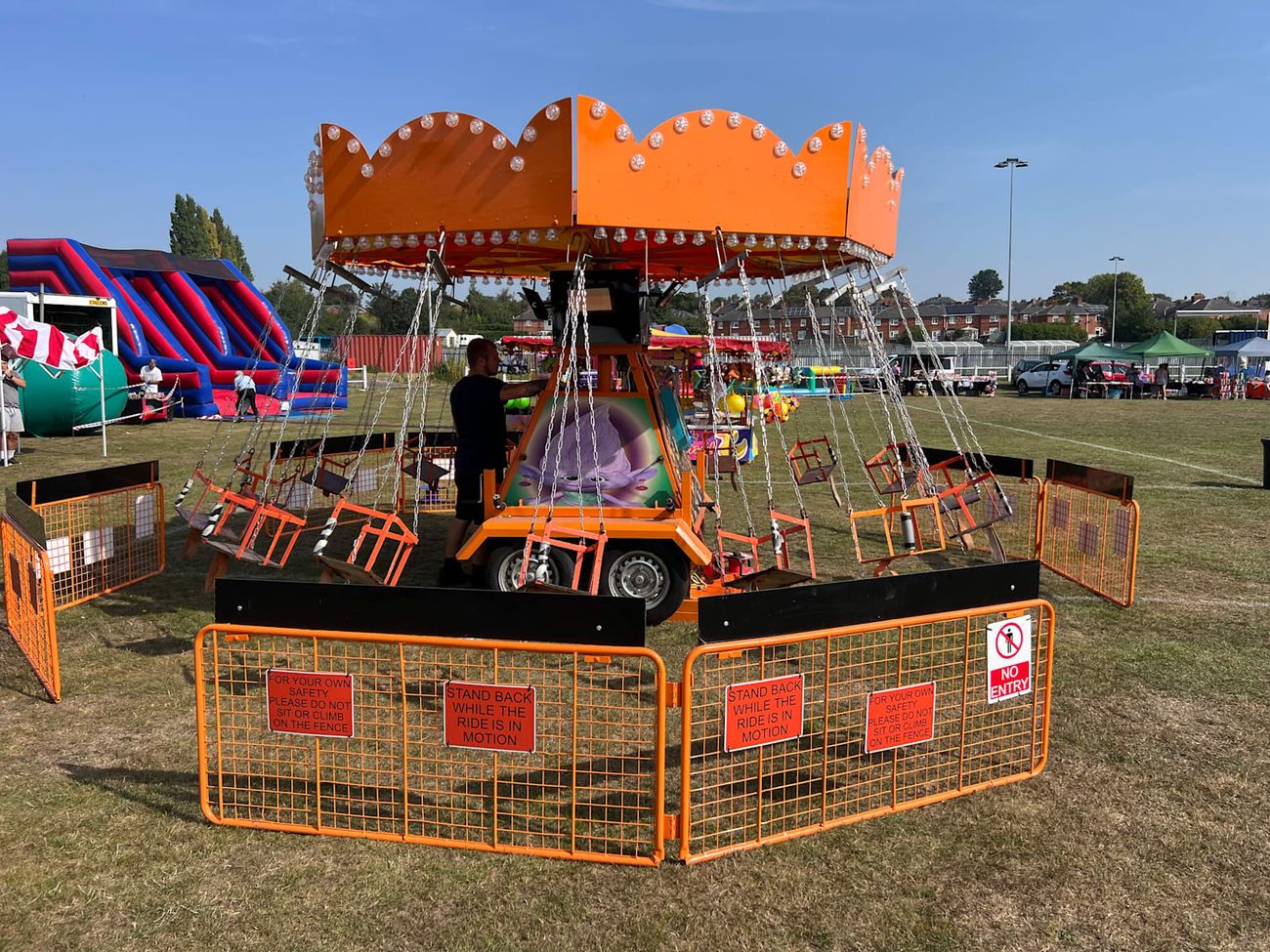 The ride operator preparing the Chair-O-Planes for boarding between cycles