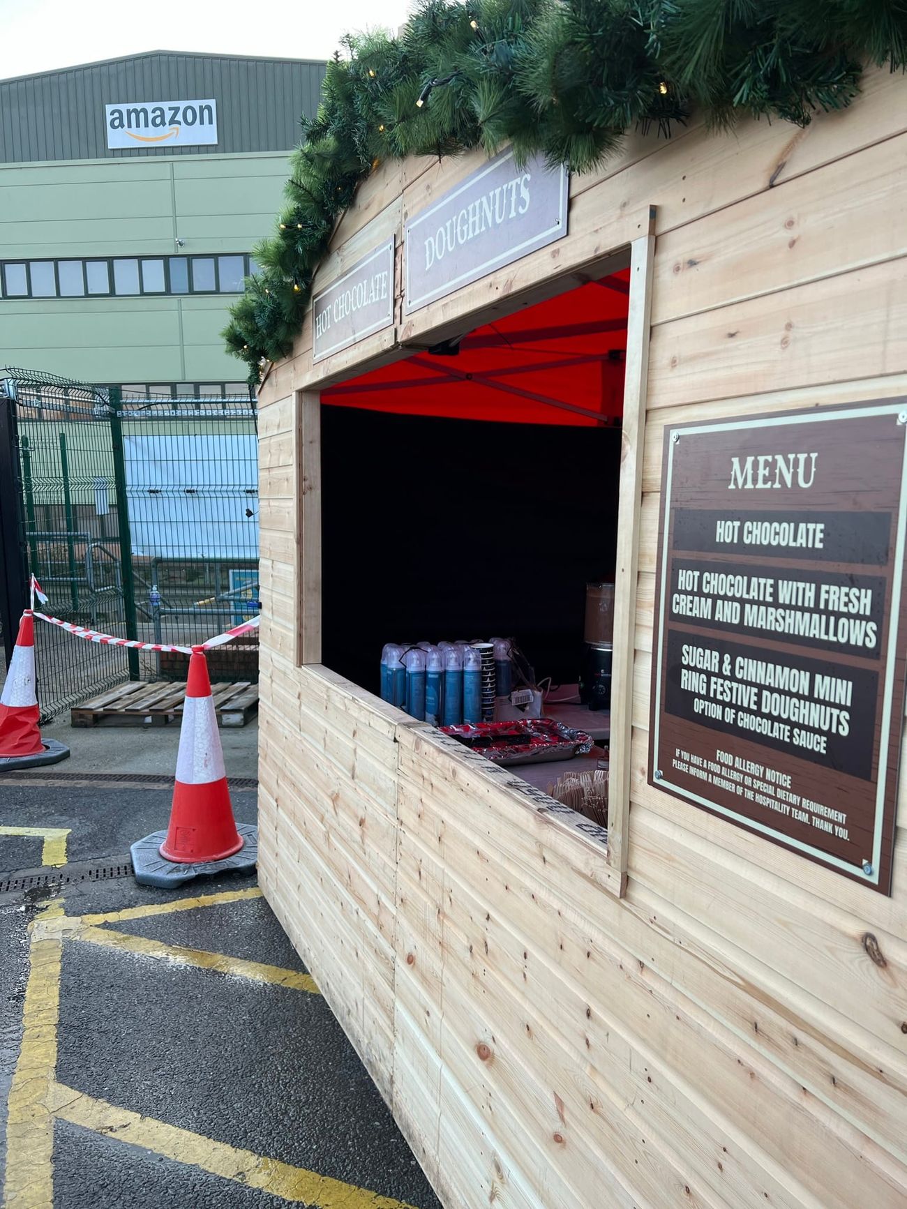 Side view of a Christmas market stall on a corporate site, with safety cones at the front