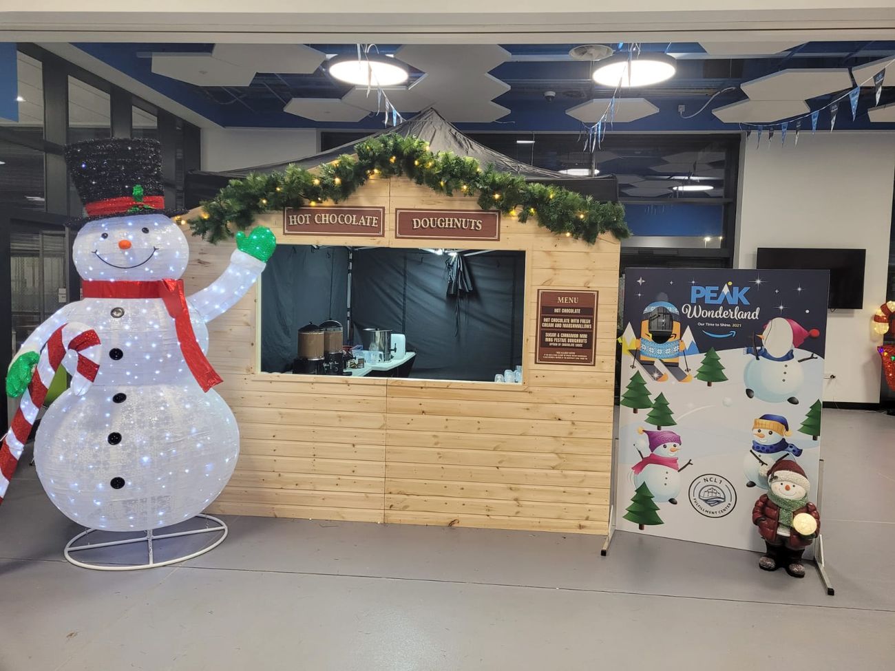 Christmas market stalls dressed into an indoor winter wonderland with a light-up snowman display