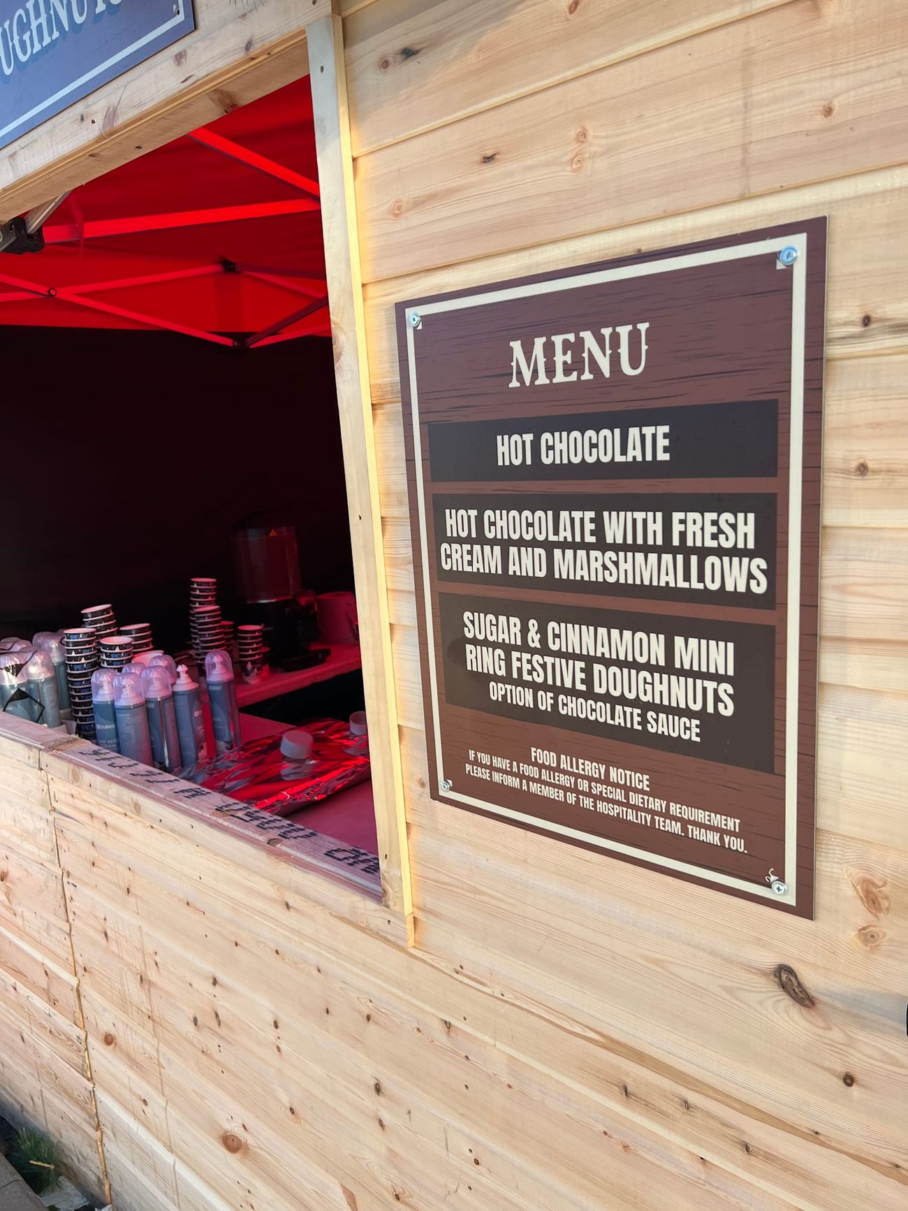 Close-up of a Christmas market stall counter's menu board and drink supplies