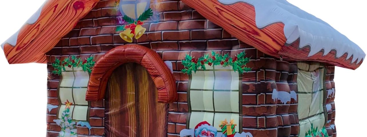 The inflatable Santa's grotto cottage with snow-capped roof, painted brick walls and Father Christmas with reindeer print