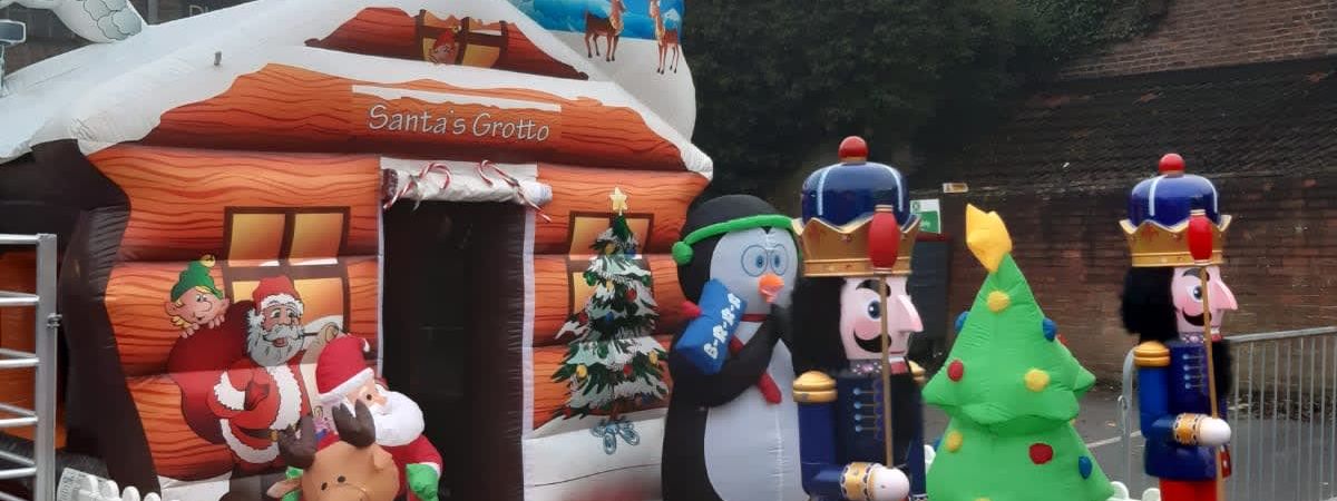 The Deluxe Santa's Grotto inflatable log-cabin shell with the printed Santa's Grotto script above the doorway