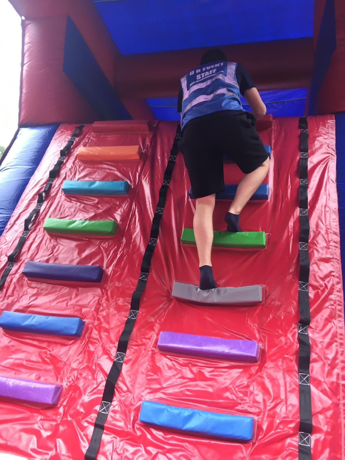 A person climbing the steep inflatable steps towards the 25ft jumping platform