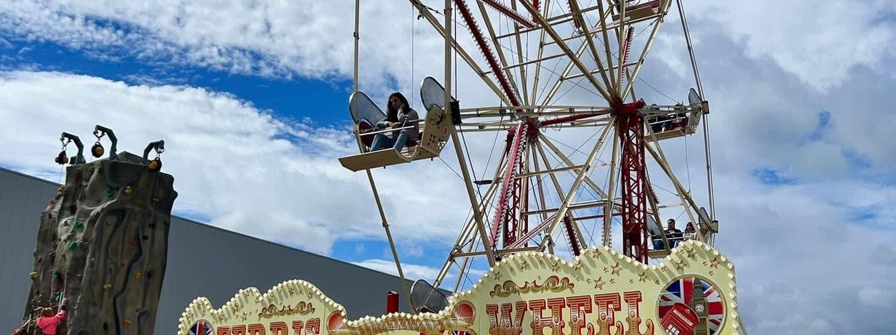 Mobile ferris wheel seen full frontage with its gondolas and platform set up on a field