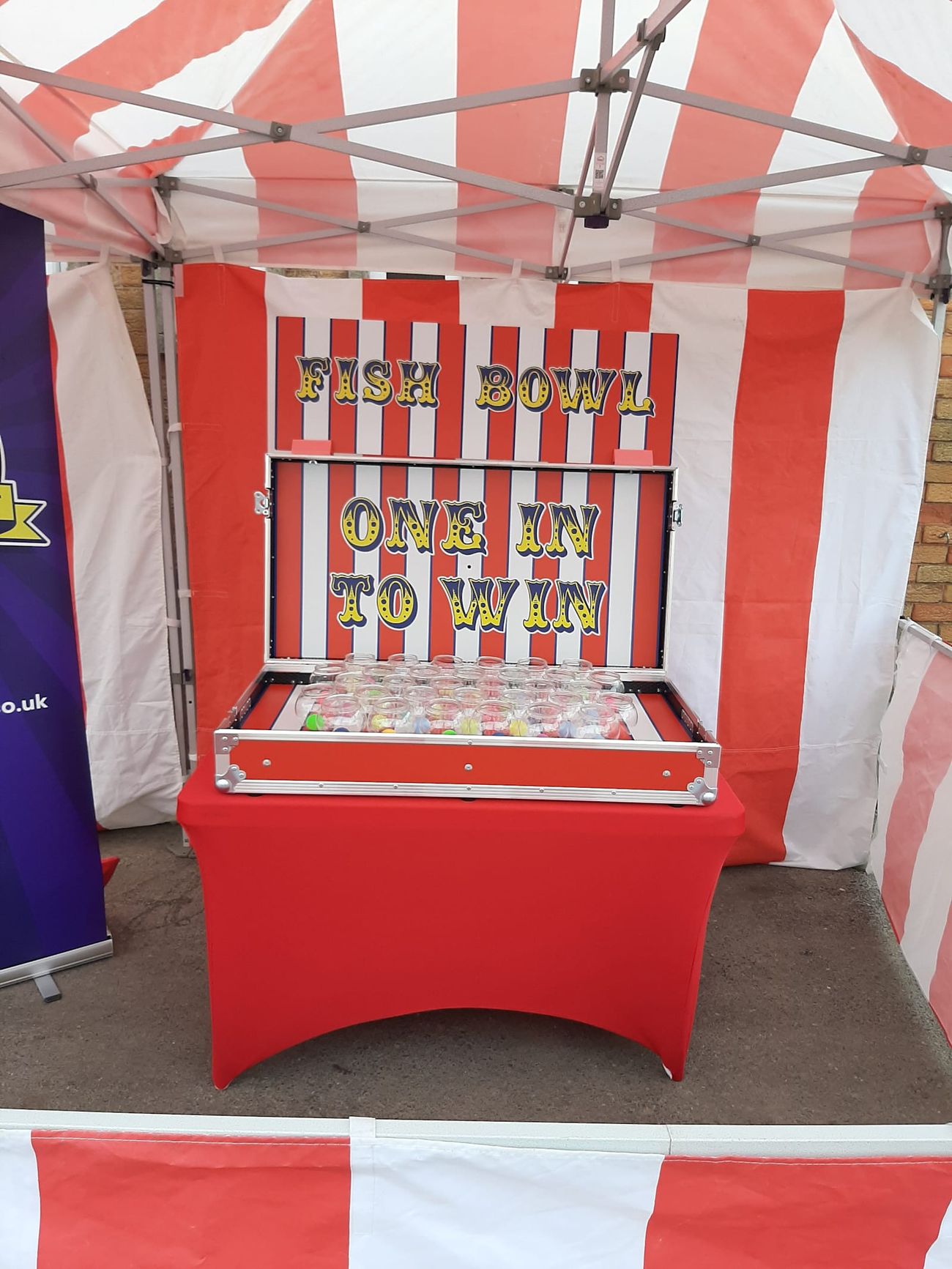 The Fish Bowl Challenge flight case opened for play, with the grid of glass bowls on the striped game board
