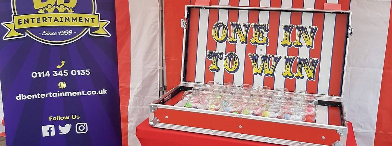 Fish Bowl Challenge stall under its red and white striped canopy, with a grid of glass fish bowls mounted on the game board