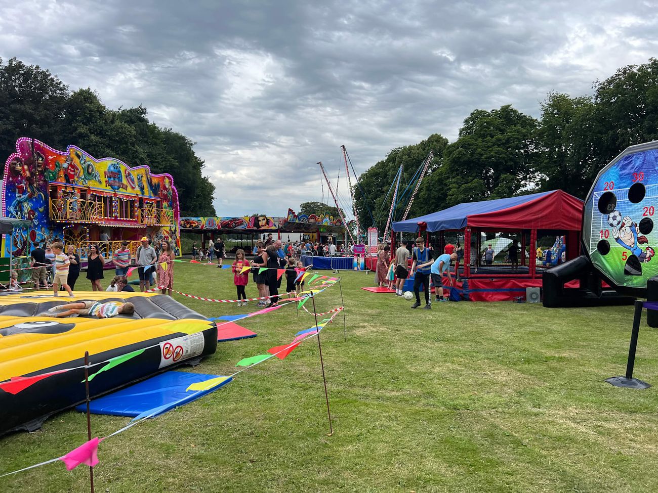 The funhouse running on a field event with visitors queueing at the ramp and other attractions spread around it
