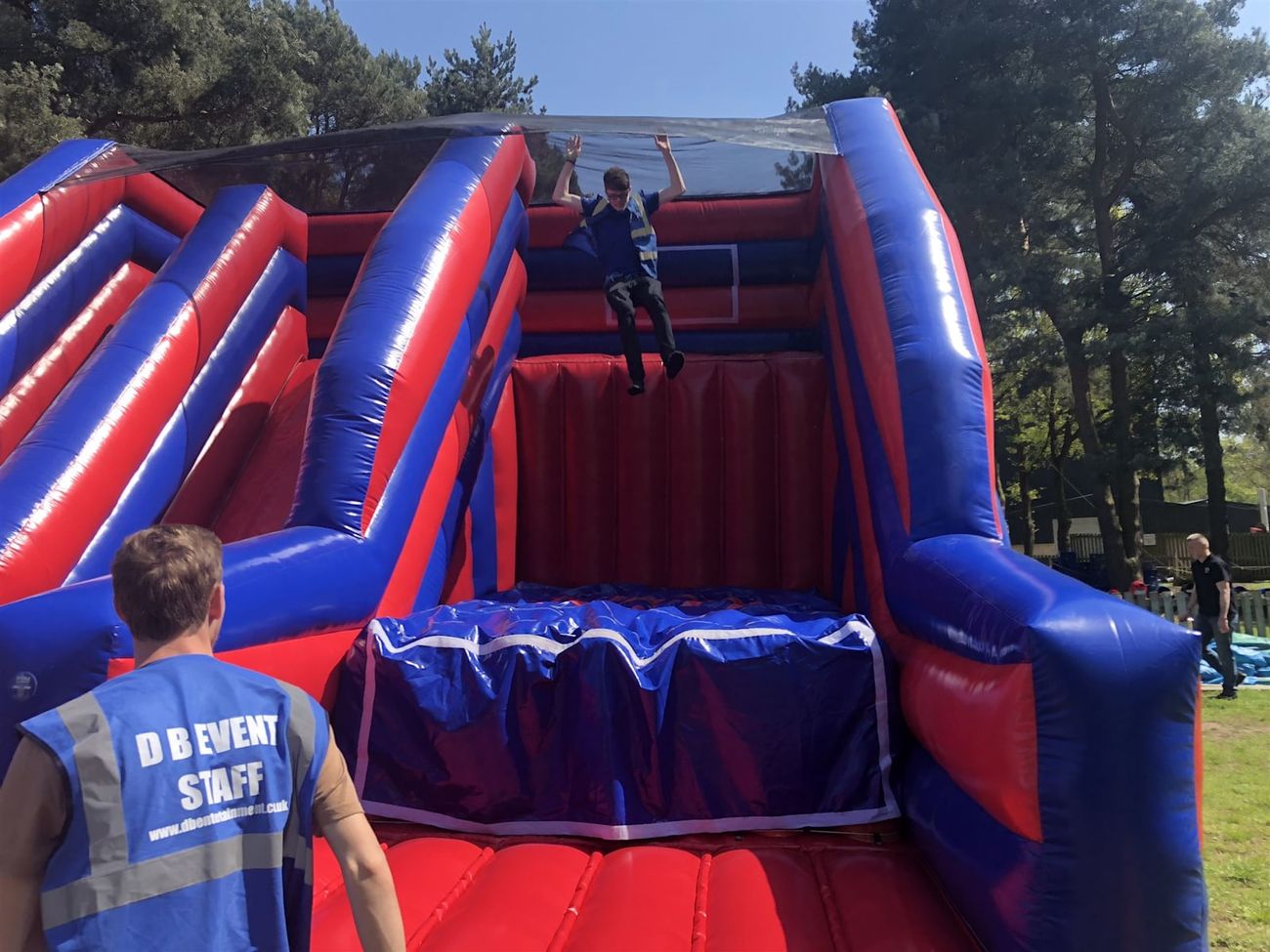Person leaping feet-first mid-air from the base jump platform into the landing pit