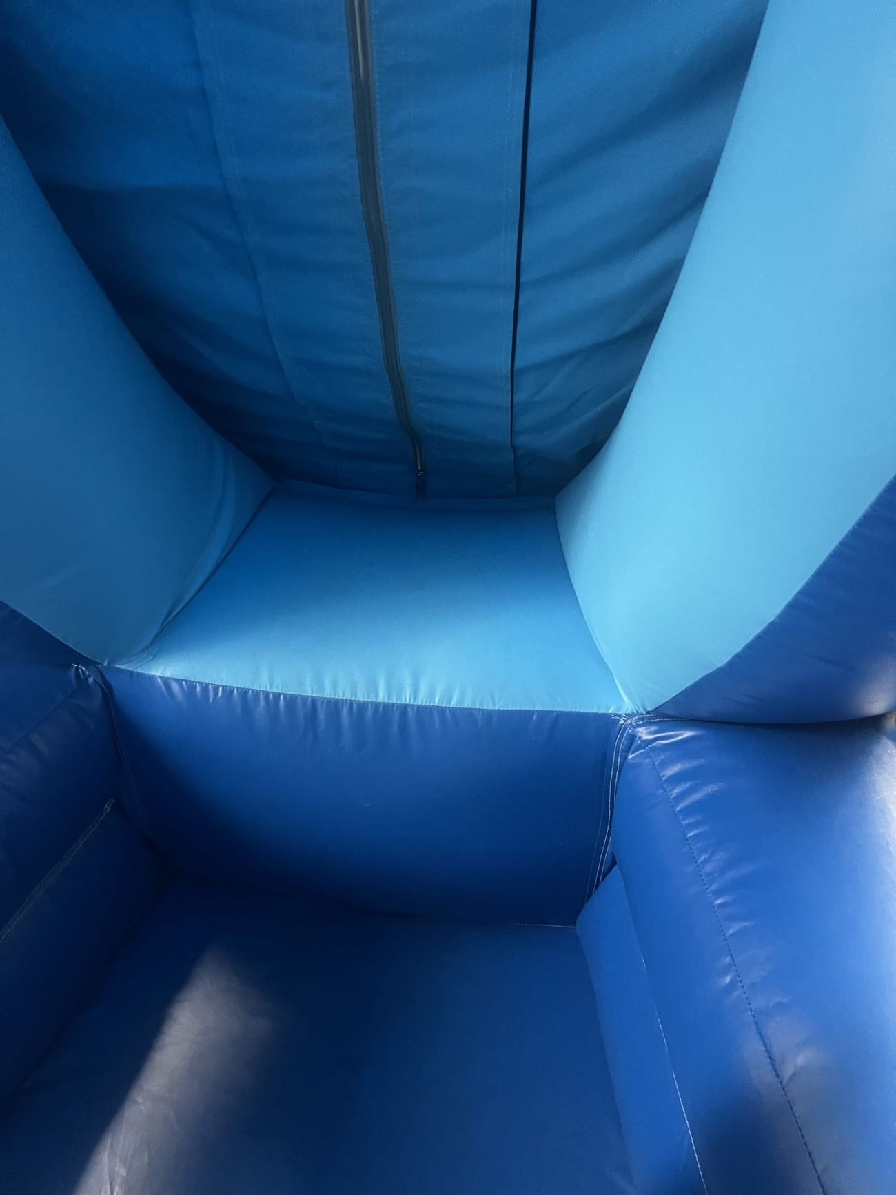 Inside the giant snow globe showing the blue padded floor and walls with the central zipper panel
