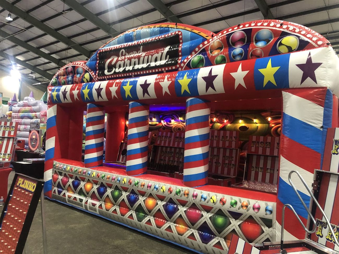 Full frontage of the Grand Carnival inflatable stall with its sign, star band and front counter