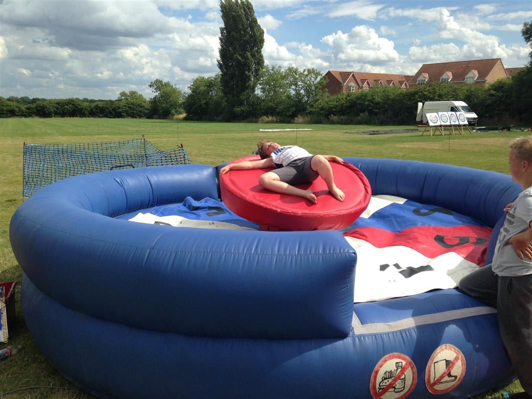 Person lying flat on the red padded roulette disc, arms stretched out, recovering after a spin