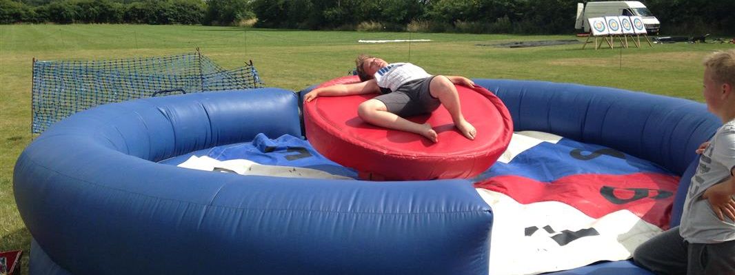 Person lying flat on the red padded roulette disc, arms stretched out, recovering after a spin