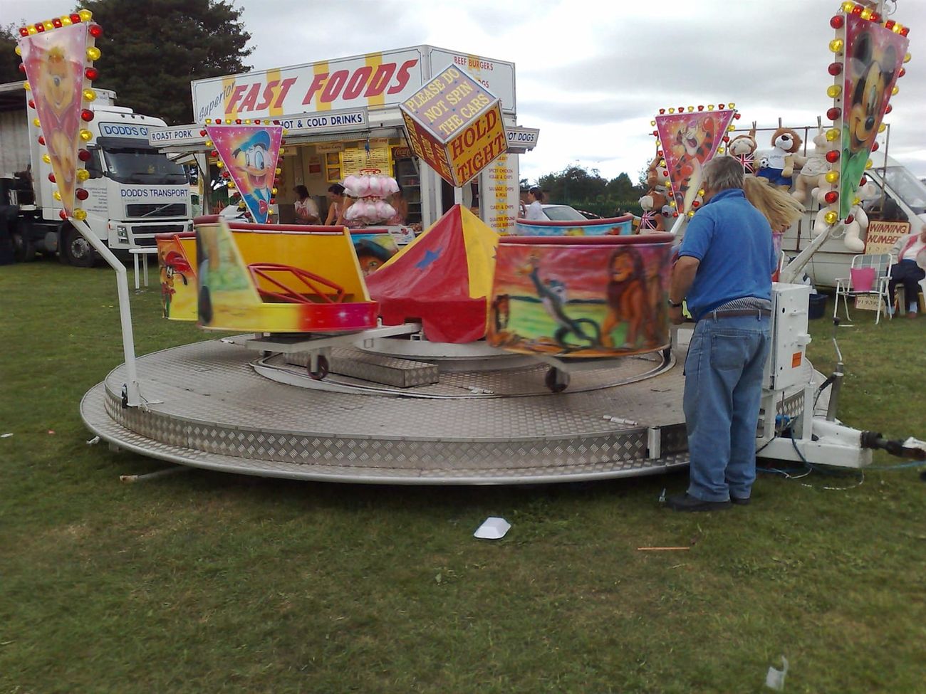 The mini waltzer set up on a grass field at an outdoor fair