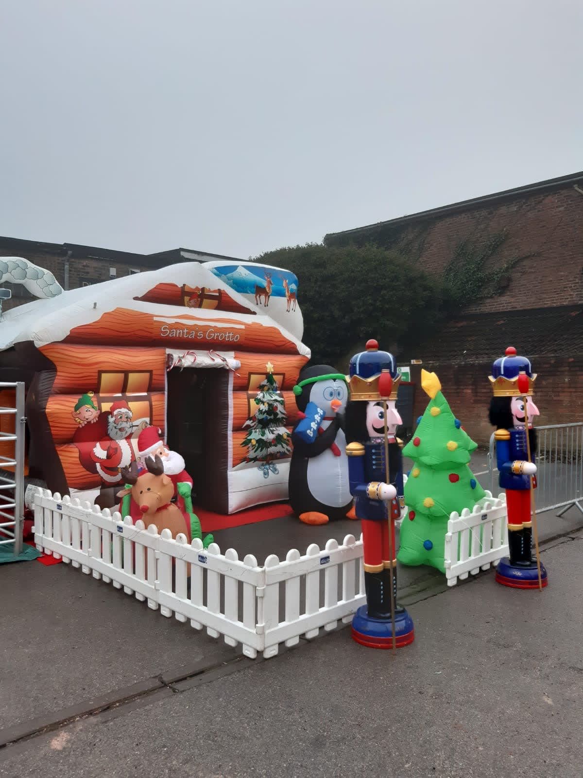 Two nutcracker figures framing an inflatable Santa's grotto setup