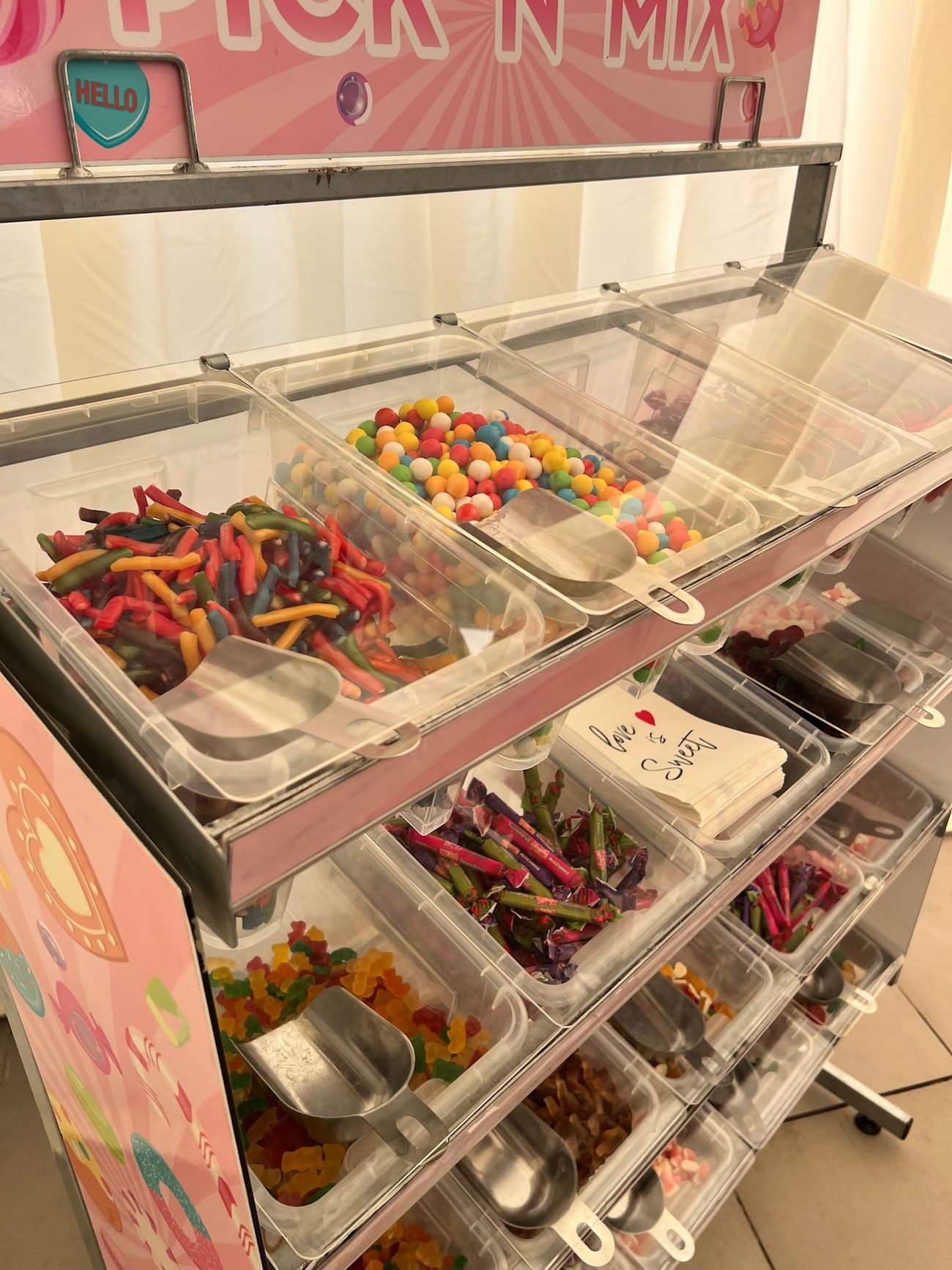 A pick 'n' mix cart themed in pastel pink for a themed event