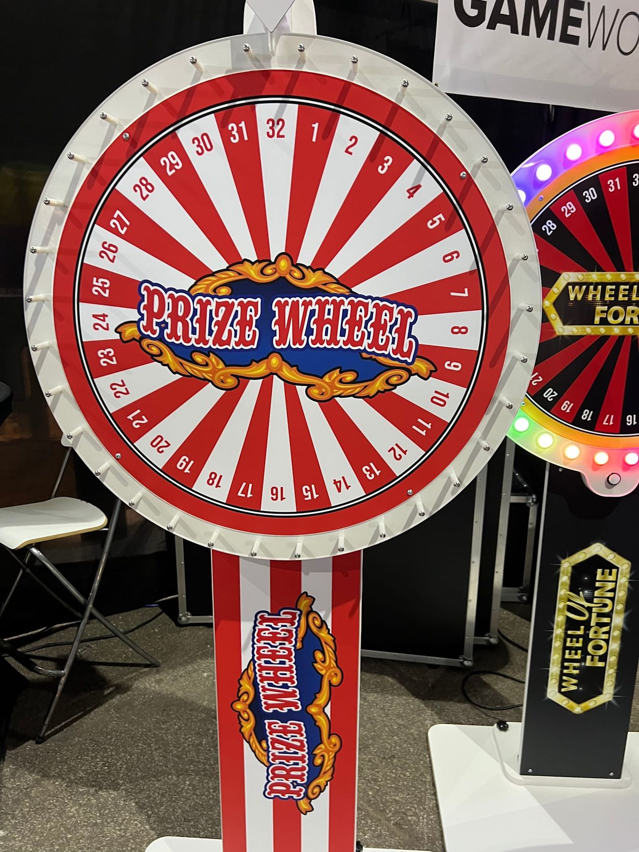 Prize Wheel with red and white segments, 32 numbered spaces and a ring of bulb lights around the rim