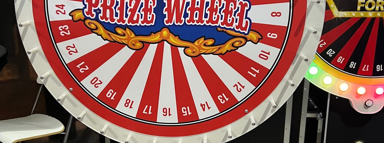 Prize Wheel with red and white segments, 32 numbered spaces and a ring of bulb lights around the rim