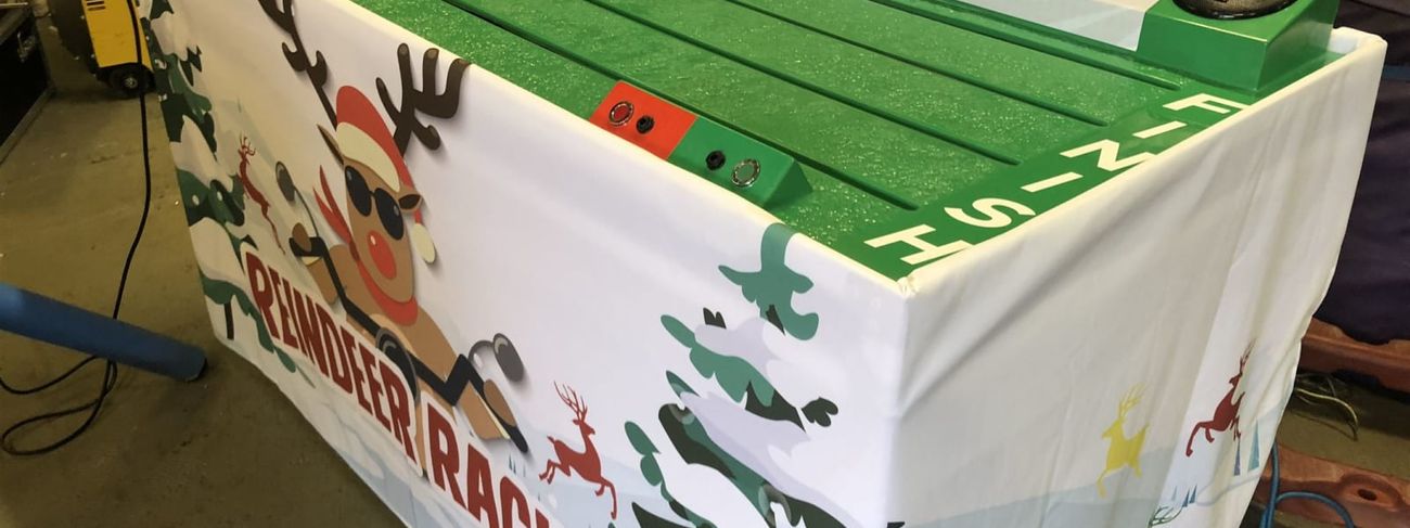 Wide view across all four colour-coded Reindeer Racing lanes at a Christmas event