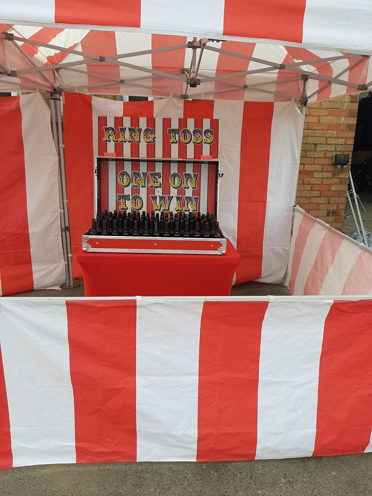 The Ring Toss stall front with the game unit on its table, bottles and rings ready for players