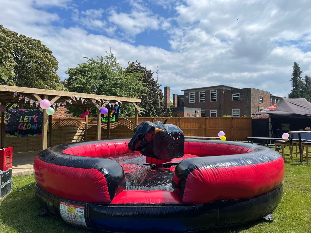 Mechanical rodeo bull on its inflatable safety bed outdoors, with black and orange-tipped horns