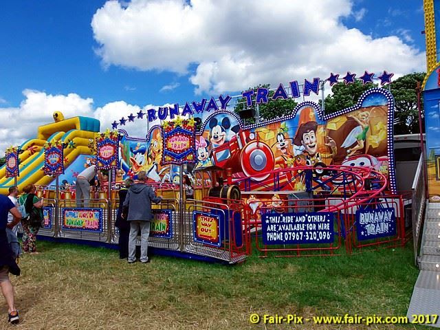 Full Runaway Train track loop on a sunny field with its painted character frontboard and fenced rails