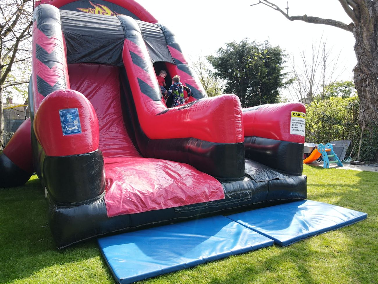 Full Rush Mega Slide structure on a lawn, showing the covered starting point and steep sliding surface