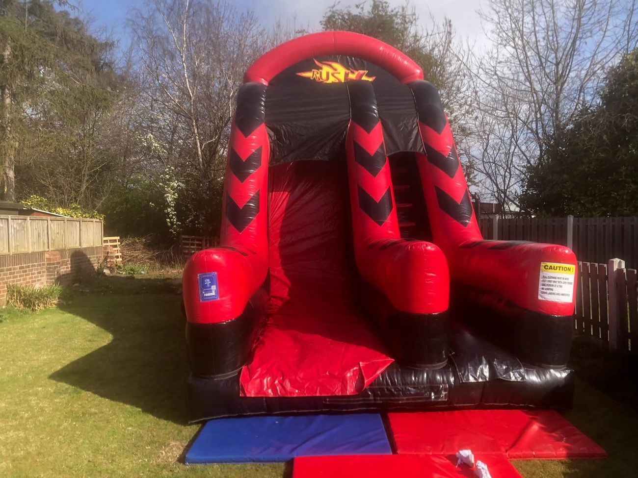 The slide with its tall arched top, set up on a field at an outdoor event