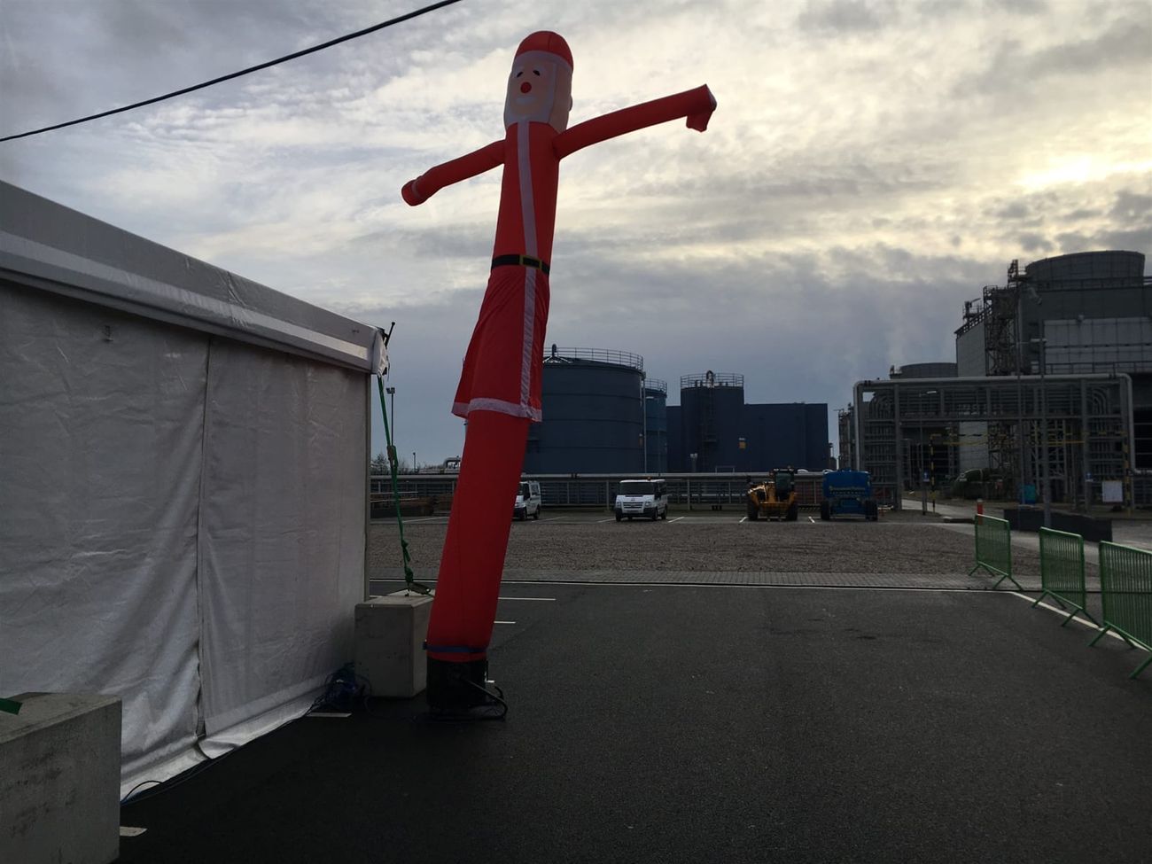 The Santa sky dancer installed at an industrial site Christmas event, with a large white marquee behind