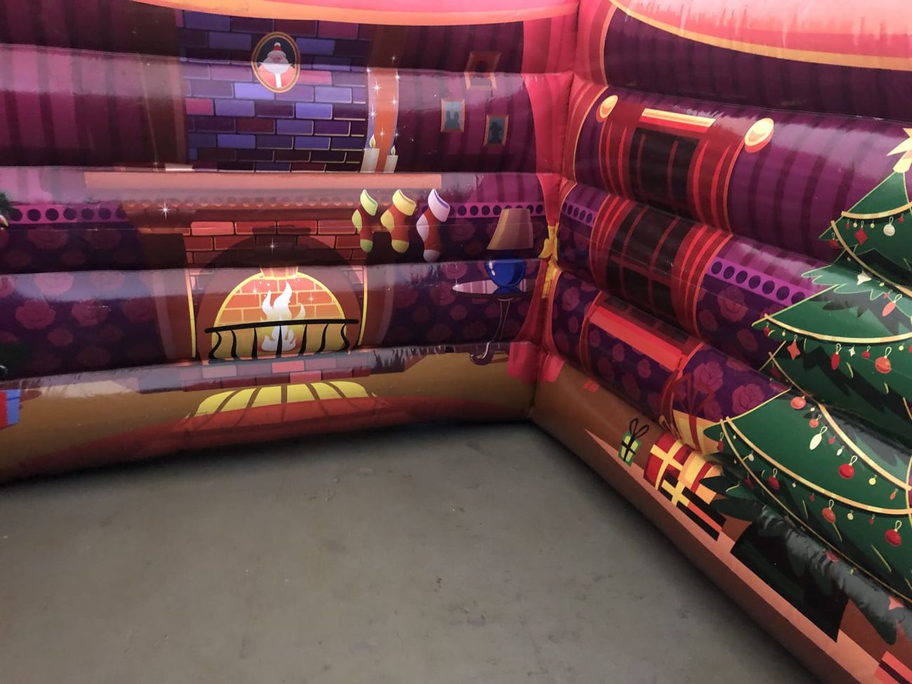 The printed fireplace and stockings on the interior wall of the Santa's grotto