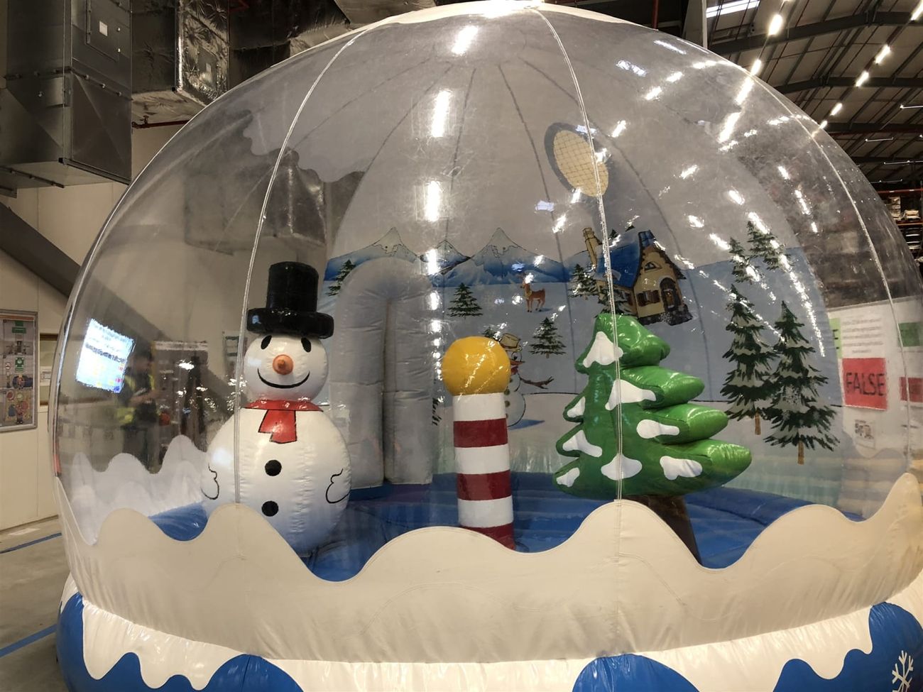 Inside the snow globe photo pod with the inflatable snowman, North Pole marker and Christmas tree