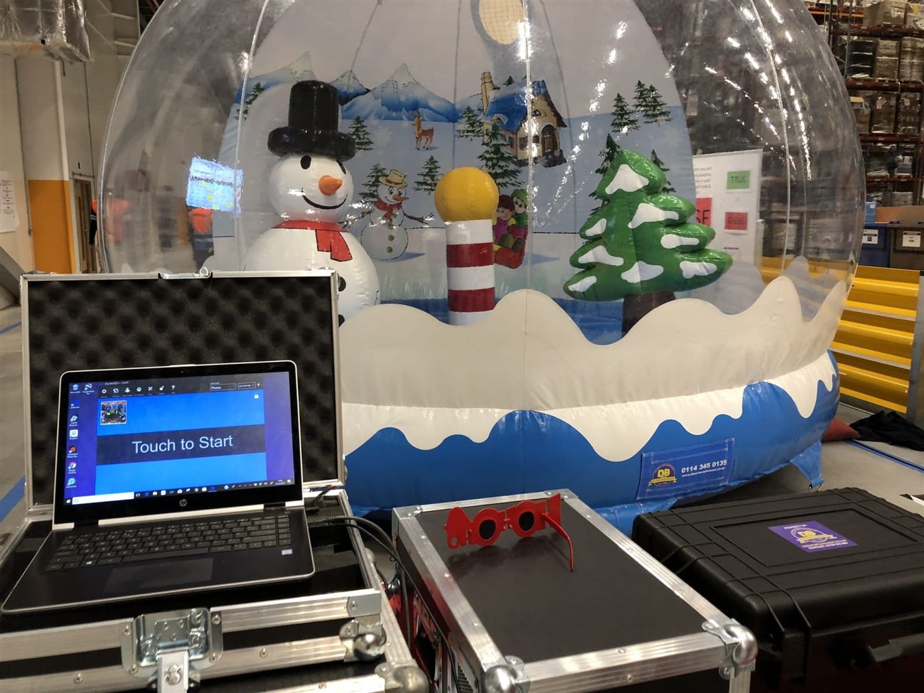 The touchscreen photo station in its flight cases beside the snow globe pod