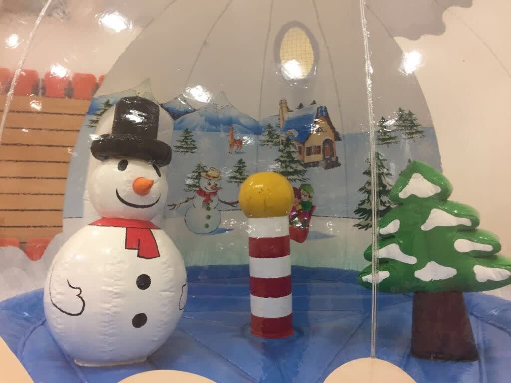 Close-up of the snow globe pod's snowman, candy-striped pole and Christmas tree