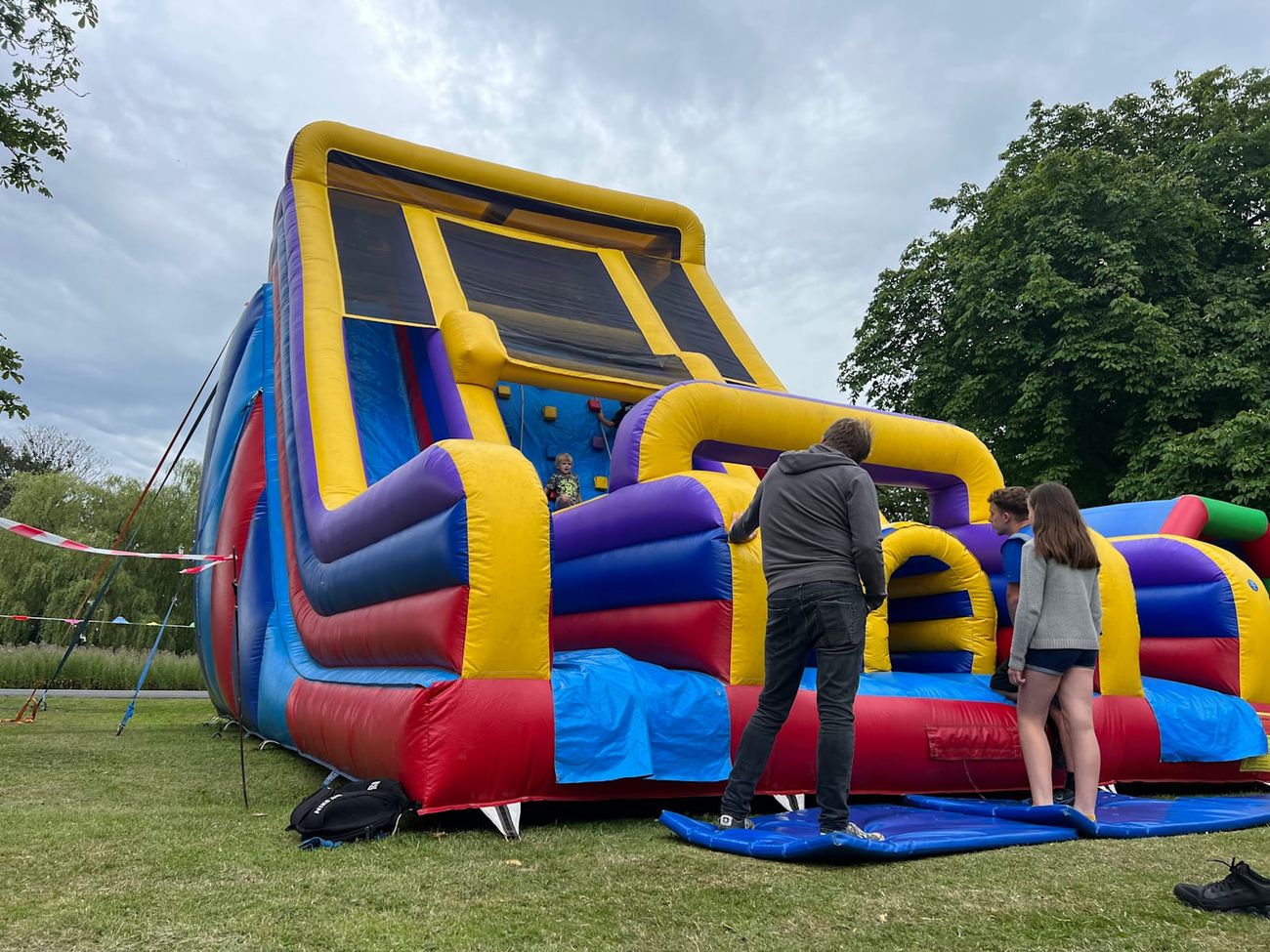The tall slide tower showing the yellow, purple, red and blue inflatable walls and safety mesh