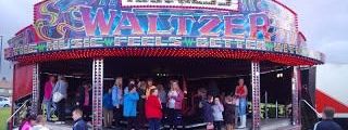 Waltzer ride lit up with bulb lighting at an evening event