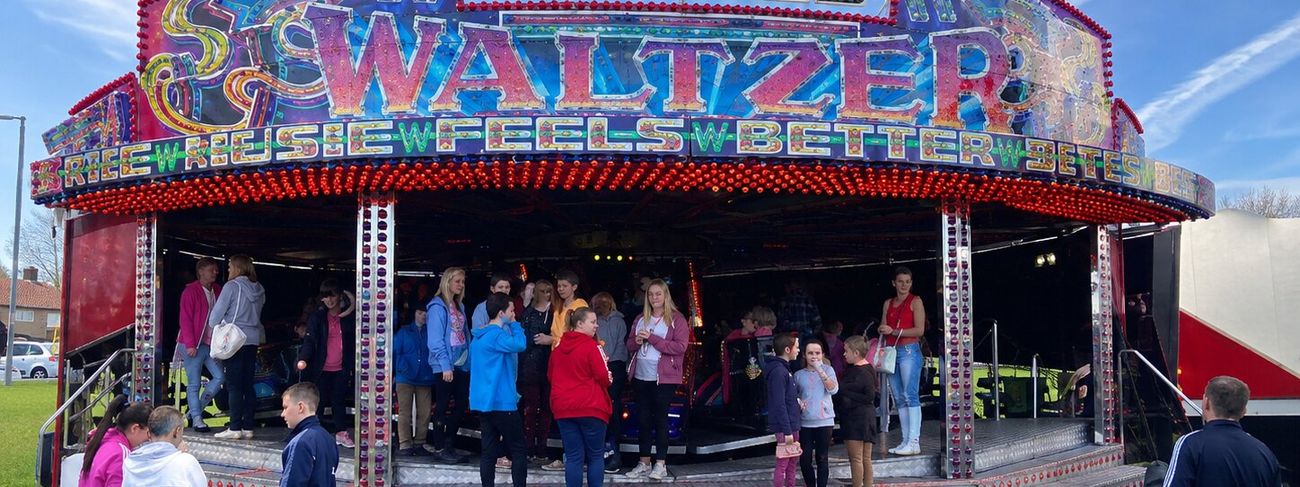 Waltzer ride set up on grass in daylight with its frontage and step in place