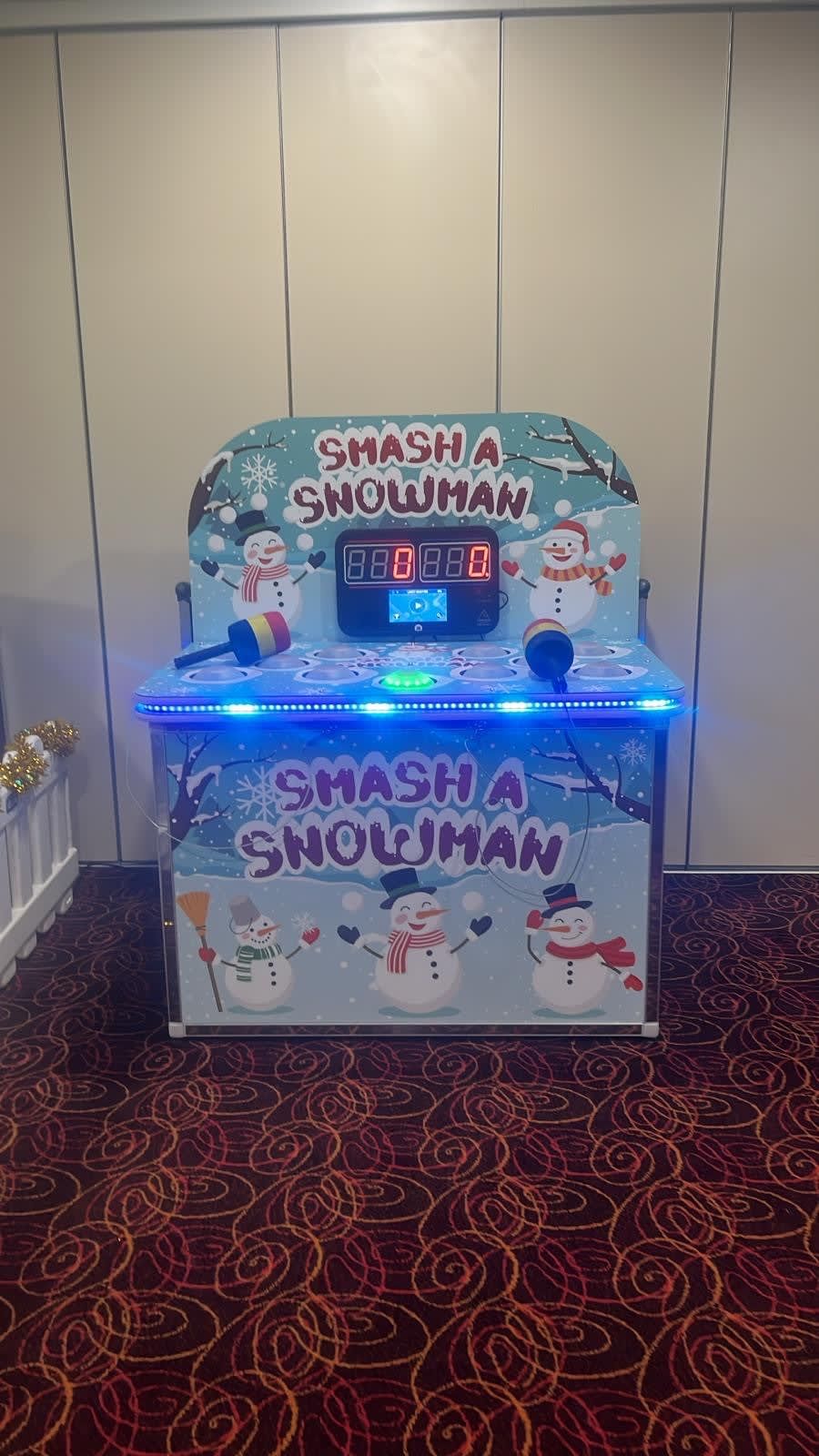 The Whack a Snowman cabinet with its snowman backboard graphics, digital scoreboard and both tethered foam mallets