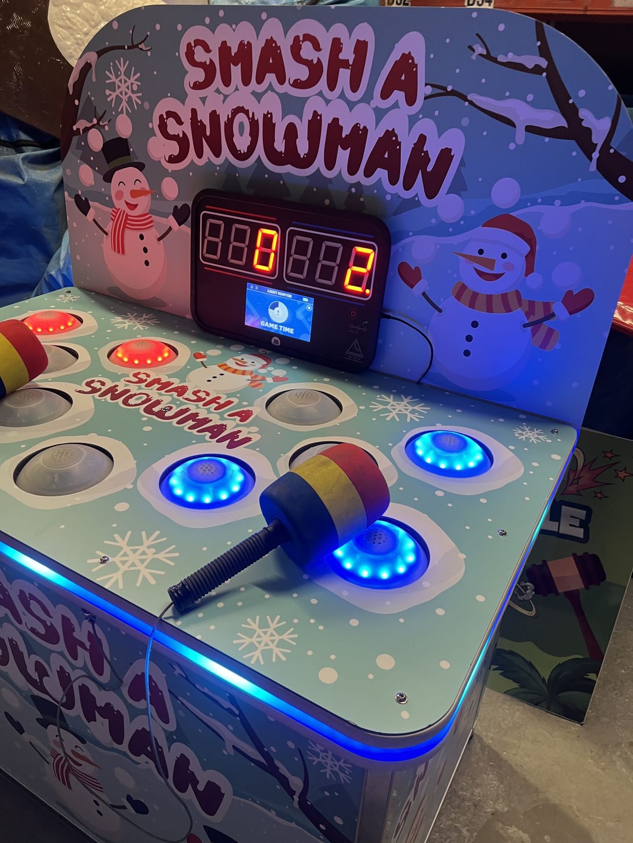 The Whack a Snowman game with lit LED targets, a foam mallet across the play surface and snowman backboard artwork
