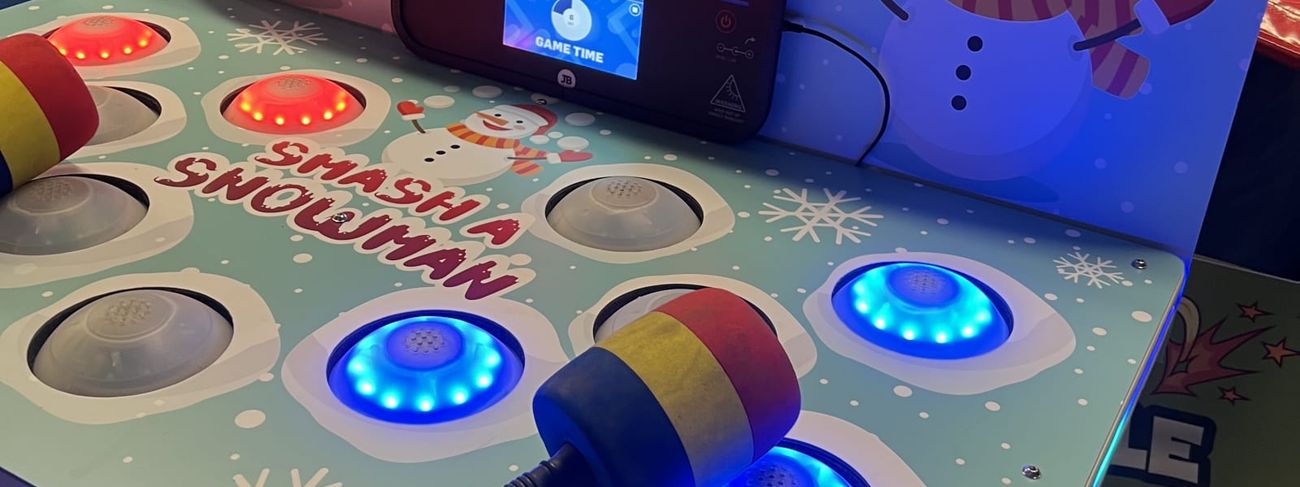 The Whack a Snowman game with lit LED targets, a foam mallet across the play surface and snowman backboard artwork