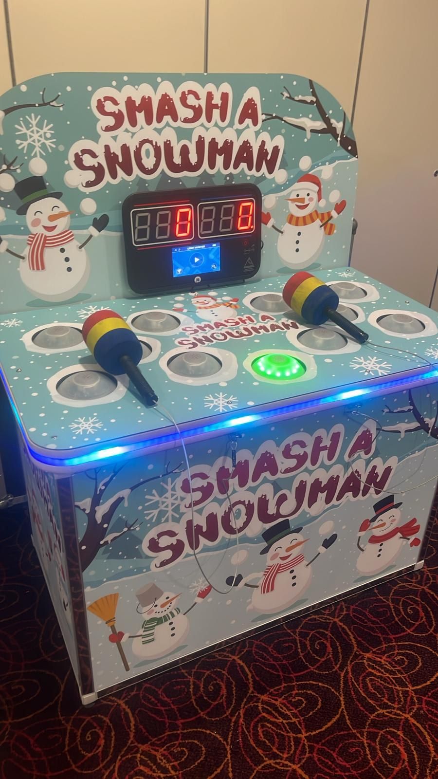 Close-up of the Whack a Snowman's green start button lit with the blue LED rim glowing